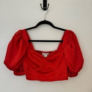Red cropped corset top with puff sleeves.
